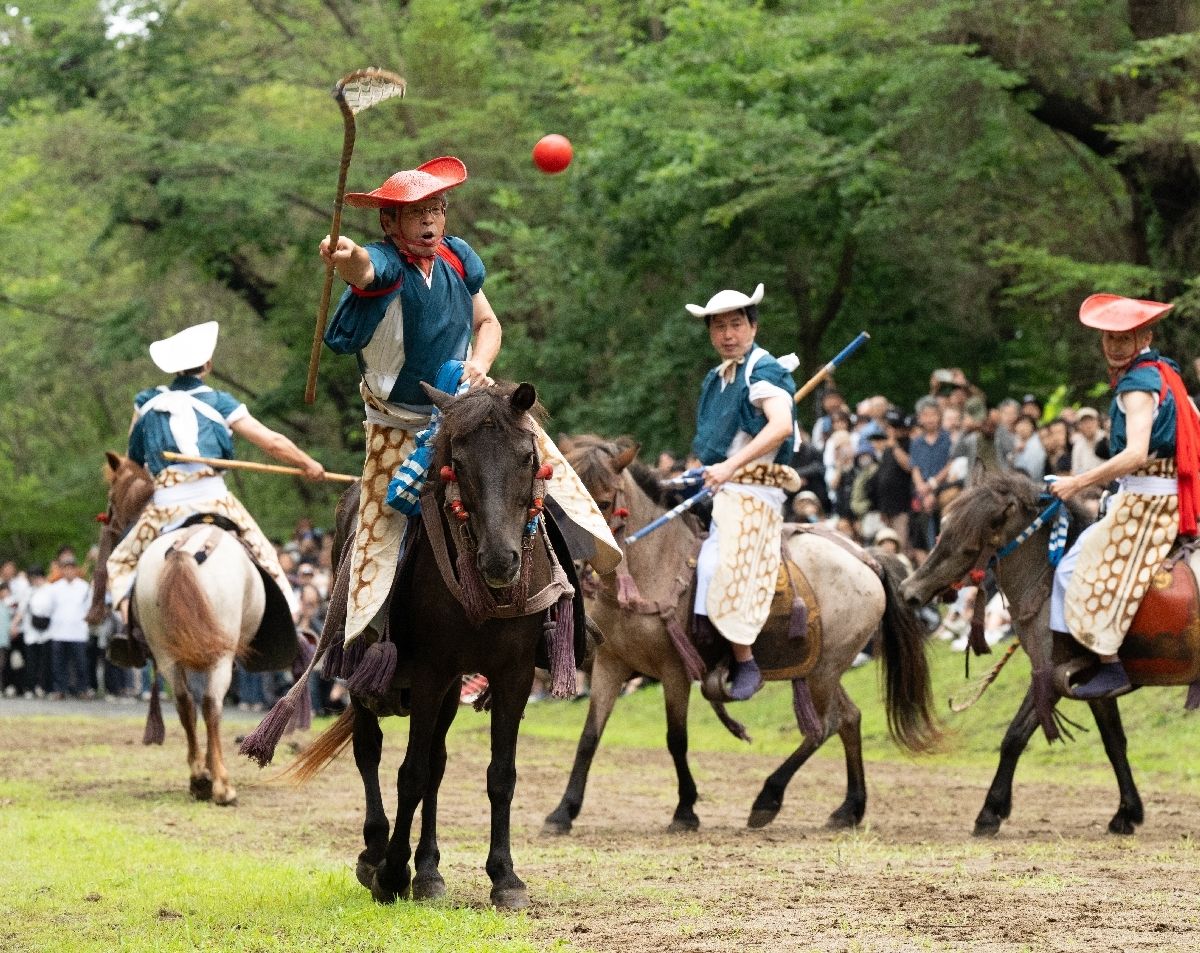毬杖を繰り、毬門を目がけて毬を投げる騎士＝２日、八戸市の長者山新羅神社